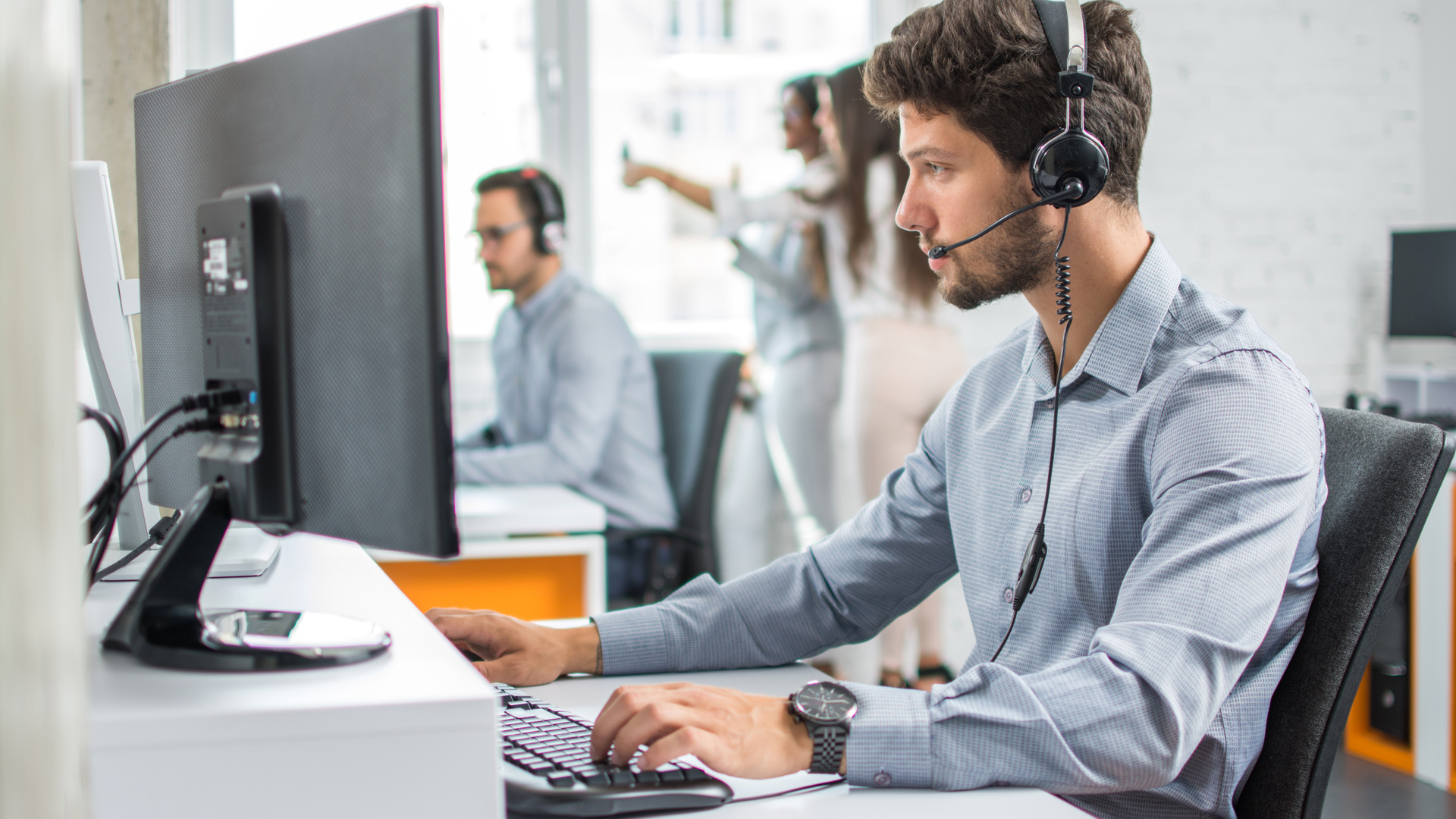 Man on service desk, with a headset on.