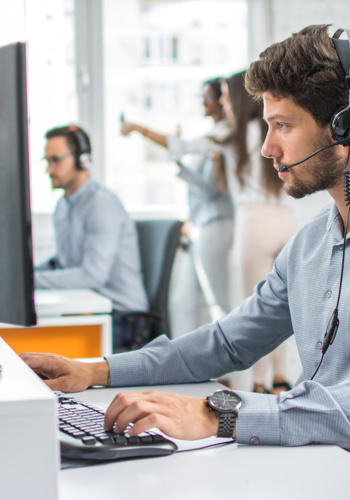 Man on service desk, with a headset on.